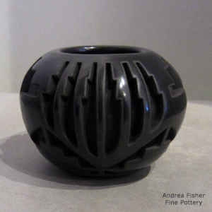 Feather, kiva step and geometric design on a black jar