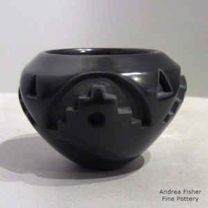 Geometric design carved into a small black jar