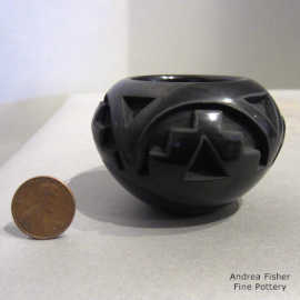 Geometric design carved into a miniature black jar