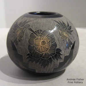 Sgraffito butterfly, flower, feather and geometric design on a black jar with sienna spots