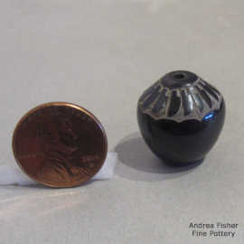 Miniature black seed pot decorated with a sgraffito ring of feathers design 