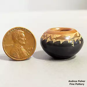 Miniature black bowl with a sienna rim and a sgraffito avanyu and geometric design