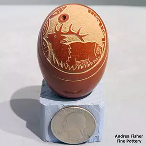 An elk and geometric design on a miniature red seed pot
