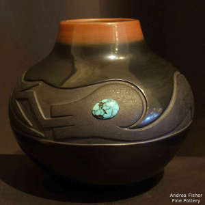 Black jar with a sienna rim and lightly carved avanyu design plus inlaid turquoise and partially slipped with micaceous clay, Click for a larger version Lightly carved avanyu design with inlaid turquoise on a black jar with a sienna rim and partially slipped with micaceous clay