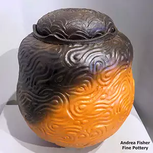 A lidded polychrome acorn-shaped jar with moulded designs and fire clouds