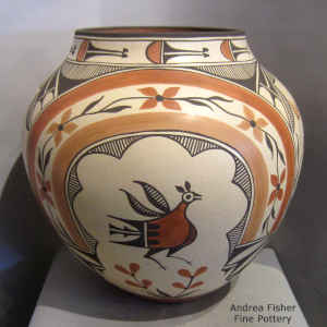 Rainbow, roadrunner, flower, rain cloud and geometric design on a polychrome jar