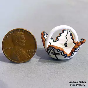 A tadpol;e and dragonfly design on a miniature polychrome Zuni prayer bowl