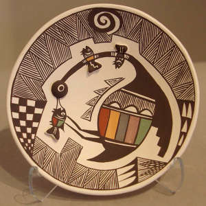 Bird, fish and geometric design with raised fish bodies on a polychrome plate