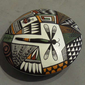 Geometric design surrounds a raised dragonfly body and ladybug on a polychrome seedpot