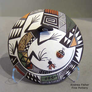 Lizard, lady bug and geometric design on a polychrome seed pot