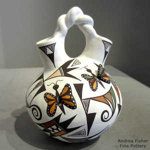 Butterfly, dragonfly, shard and geometric design on a polychrome wedding vase with a twisted handle