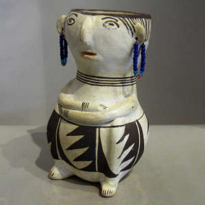 Geometric design and earrings on a polychrome effigy jar