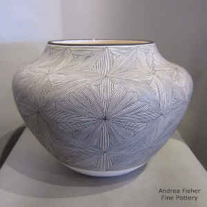 Fine line snowflake design on a black and white storage jar