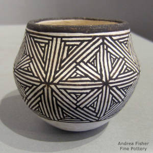 Fine line snowflake design on a black and white jar