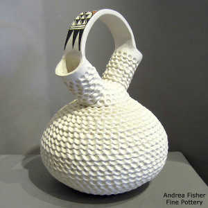 Polychrome geometric design on the handle of a corrugated whitre wedding vase