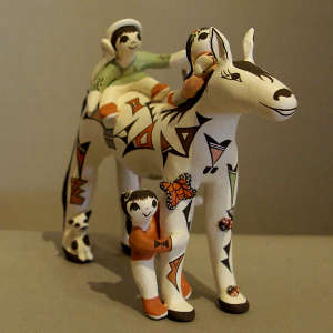 3 children and a geometric design on a polychrome horse