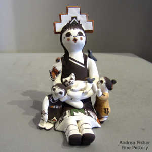 Two children, a cat, a bird a butterfly and a tablito on a female storyteller