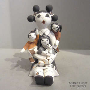 Three children, kitten, bird, butterfly and ladybug on a seated grandmother storyteller figure