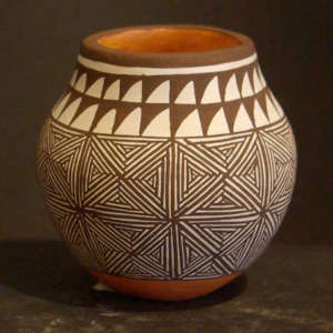 Black and white snowflake fine line and geometric design on a small polychrome jar