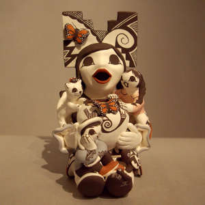 Two children and a cat on a storyteller wearing a tablita