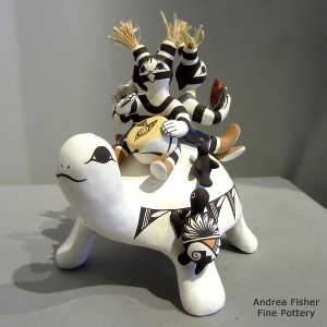 Dog, turtle, bird and butterfly share the back of a turtle with 3 young koshares