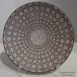 Fine line and swirl geometric design on a black and white plate