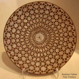Fine line and geometric design on a black and white plate
