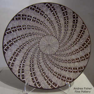 Fine line and swirl geometric design on a black and white plate