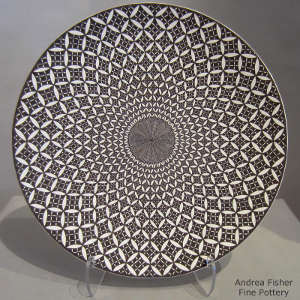 Fine line and geometric design on a black and white plate