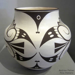 Bird element and geometric designs decorate a black and white jar