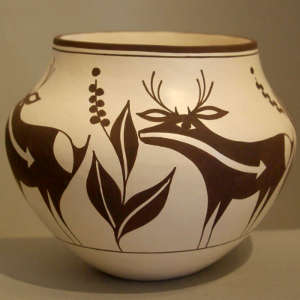 Deer, heartline and plant design on a black and white jar