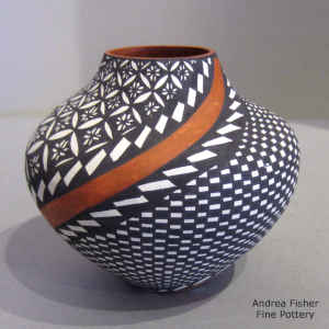 Checkerboard, pumpkin seed and spiral geometric design on a polychrome jar