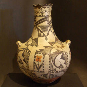Flower, bird element and geometric designs on a long neck polychrome jar