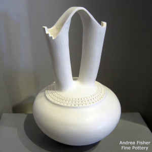 A band of corrugtion runs around the spouts of this white wedding vase