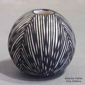 Fine line design on a miniature black and white jar