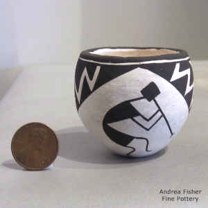 Kokopelli and a geometric design on a miniature black and white jar