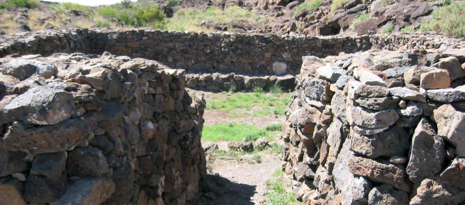 Looking between the stone walls of the entryway to the square kiva