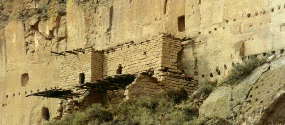 A stone building extending out from the volcanic tuff cliff