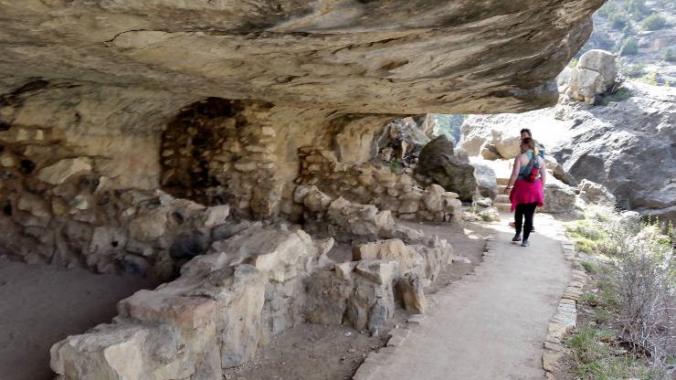 A group of reconstructed dwellings under an overhang in the cliff wall in Walnut Canyon
