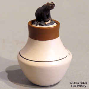 Polychrome miniature jar with a fish design and a brown bear on the lid