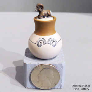 Miniature polychrome jar with a ram's horn design and a bighorn ram sitting on the lid