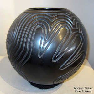 Handprint and outlines carved into a burnished black jar