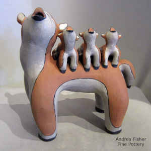 Coyote storyteller with 3 pups on her back