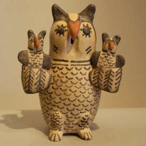 Two owls on the wings of a polychrome owl storyteller