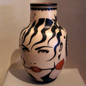 Two faces holding roses in their mouth on a tall-neck polychrome jar