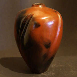 Carved swirl lines and fire clouds on a red jar