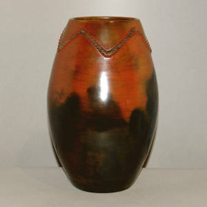 Biyo around the neck of a brown jar with black fire clouds