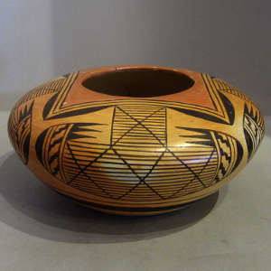 Red and black four direction bat wing pattern and geometric design on a yellowware pot