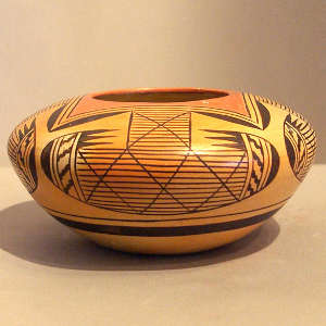 Red and black four direction bat wing pattern and geometric design on a yellowware jar