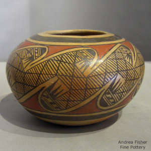 Black and red migration pattern design on a yellowware jar